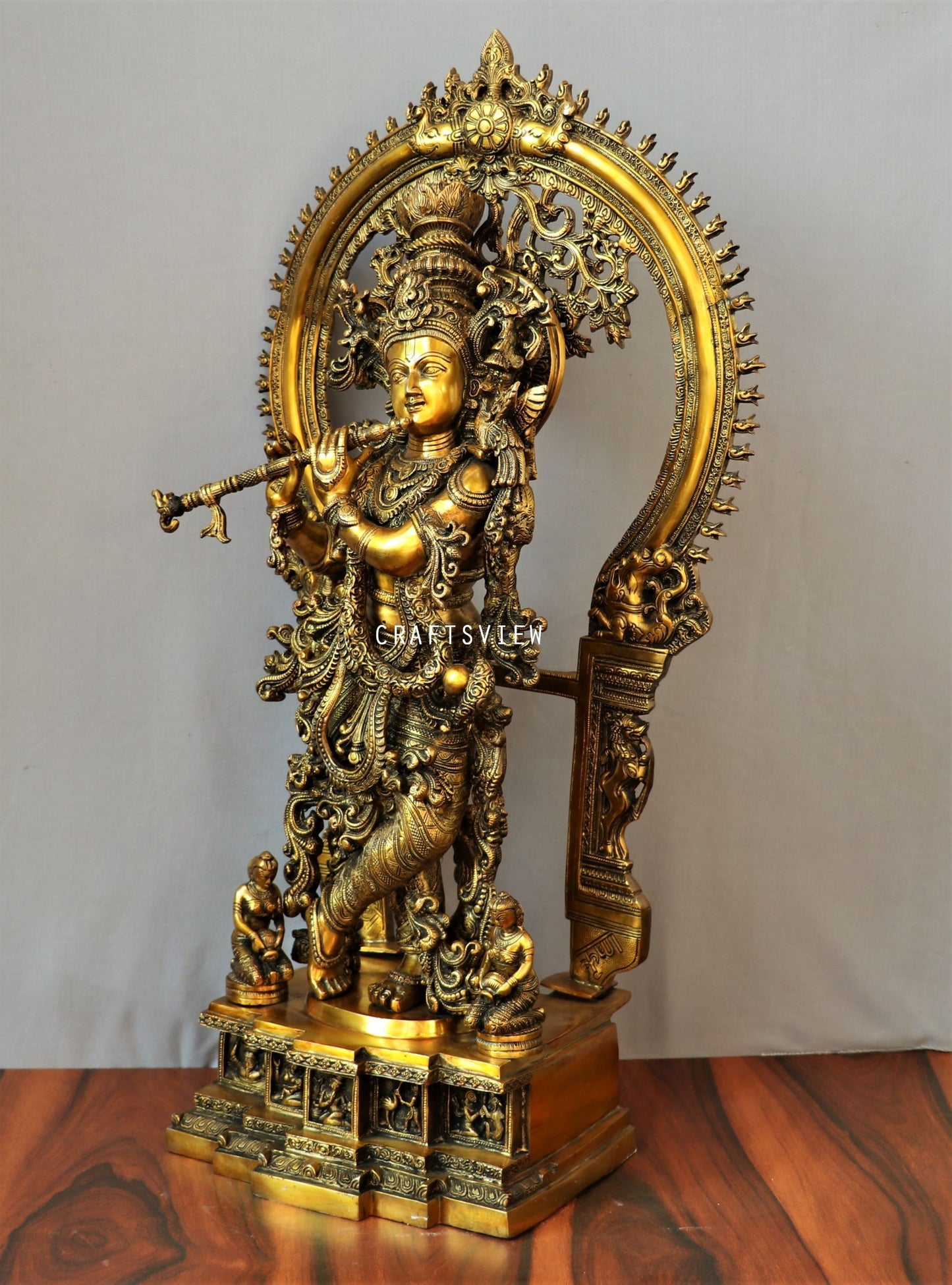 Lord Krishna stands on an engraved base with Frame 32"