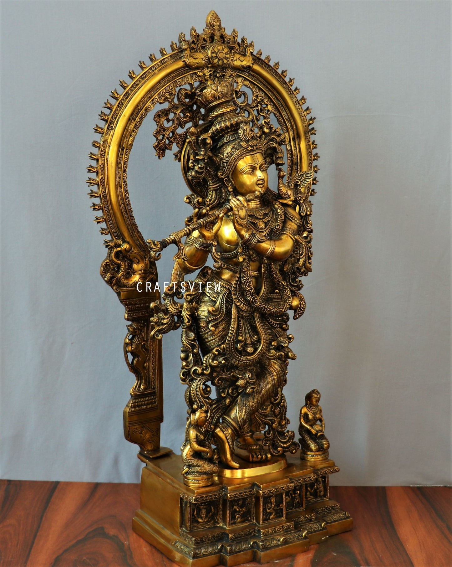 Lord Krishna stands on an engraved base with Frame 32"