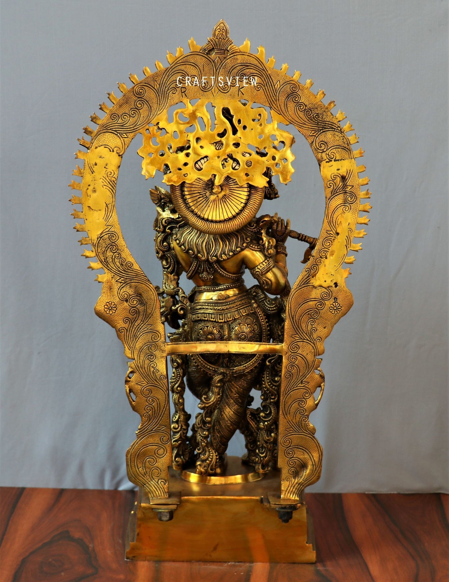 Lord Krishna stands on an engraved base with Frame 32"